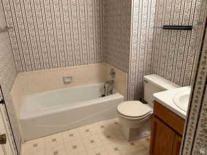 Bathroom with vanity, a bath, and toilet