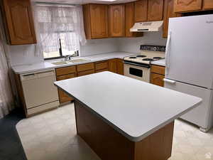 Kitchen with white appliances, sink, and a kitchen island