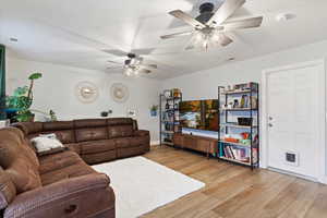 Living room with ceiling fan and light hardwood / wood-style flooring