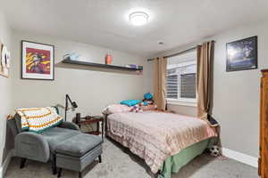 Bedroom with carpet floors and a textured ceiling