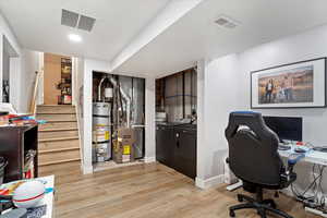 Office featuring water heater, washing machine and clothes dryer, and light hardwood / wood-style floors