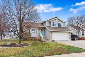 Split level home featuring a garage and a front yard