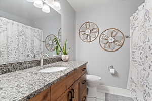 Bathroom featuring vanity, toilet, and tile patterned flooring