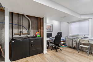 Office area featuring light hardwood / wood-style flooring, washing machine and dryer, and a textured ceiling