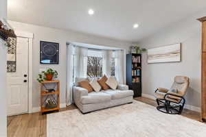 Living room featuring lofted ceiling and wood-type flooring