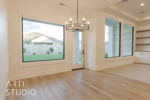 Unfurnished dining area featuring a notable chandelier and light hardwood / wood-style floors