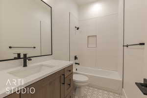 Full bathroom featuring tiled shower / bath, vanity, and toilet