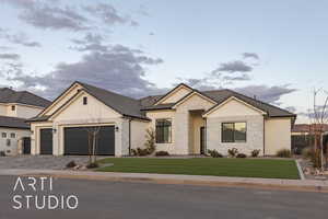 View of front of home with a garage and a front lawn