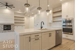 Kitchen with white cabinetry, sink, a center island with sink, and appliances with stainless steel finishes