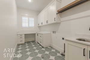 Laundry area with washer hookup, sink, cabinets, and hookup for an electric dryer