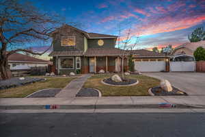 View of front property featuring a garage and a yard