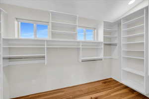 Walk in closet with vaulted ceiling and hardwood / wood-style floors