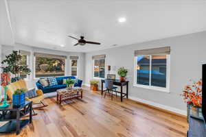 Living room with ceiling fan and light wood-type flooring