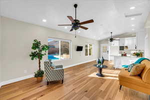 Living room featuring lofted ceiling and light hardwood / wood-style flooring