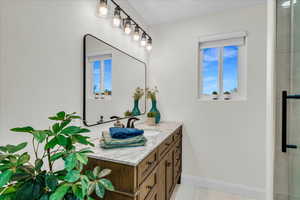 Bathroom with tile patterned floors, vanity, and an enclosed shower