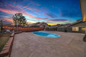 Pool at dusk featuring a patio area