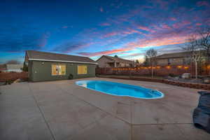 Pool at dusk with a patio area