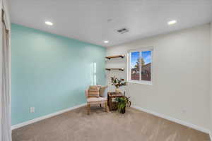 Living area featuring light colored carpet