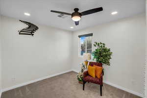 Sitting room with light colored carpet and ceiling fan