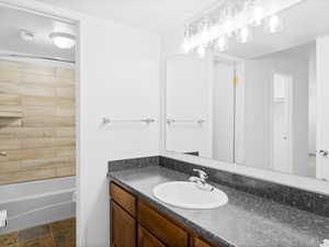 Full bathroom featuring vanity, tiled shower / bath combo, and toilet