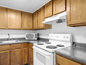 Kitchen featuring sink and white range with electric cooktop