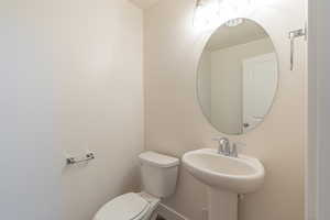 Half bath featuring toilet and baseboards