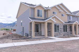 View of front of home with a mountain view, board and batten siding, a porch, and stone siding