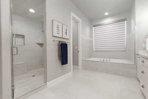 Bathroom with tile patterned flooring, vanity, and plus walk in shower