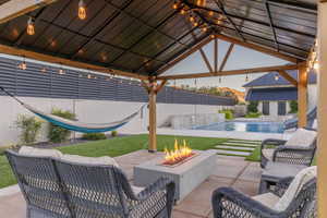 View of patio / terrace featuring a gazebo, a fenced in pool, and a fire pit