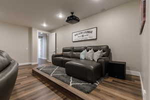 Home theater room with dark wood-type flooring