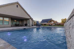 View of swimming pool featuring a gazebo, a patio, and a water slide