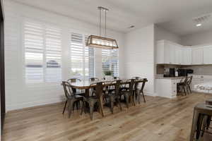 Dining area featuring built in desk, light hardwood / wood-style flooring, and a wealth of natural light