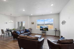 Living room with an inviting chandelier, hardwood / wood-style flooring, and a textured ceiling