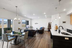 Dining room with sink, a notable chandelier, and dark hardwood / wood-style flooring