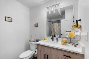 Bathroom with vanity, toilet, and a shower with shower curtain