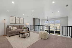 Carpeted living area featuring a chandelier and recessed lighting