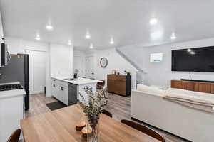 Kitchen featuring white cabinetry, appliances with stainless steel finishes, sink, and light wood-type flooring