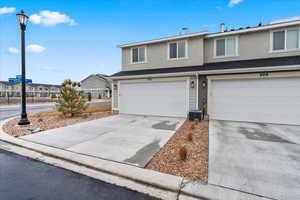 View of property featuring central AC unit and a garage