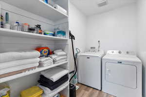 Washroom featuring washing machine and dryer and light wood-type flooring