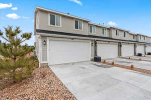 View of front of home featuring a garage and central AC