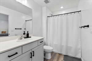 Bathroom featuring vanity, wood-type flooring, and toilet