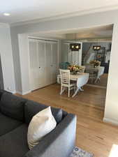 Living room featuring crown molding, a chandelier, and hardwood / wood-style floors