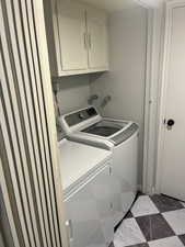 Washroom with separate washer and dryer and cabinets