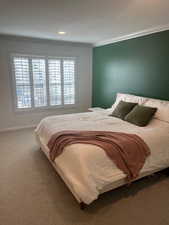 Bedroom featuring crown molding and carpet floors