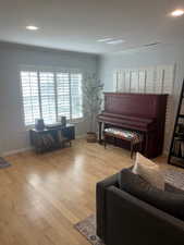 Living room featuring crown molding and light hardwood / wood-style floors