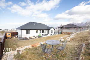 Rear view of house featuring a mountain view, a yard, and a patio area