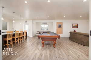 Rec room with sink, light hardwood / wood-style floors, and billiards