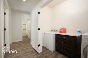 Laundry area with washer / dryer and light wood-type flooring