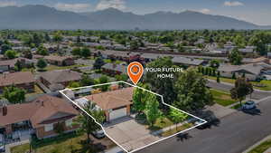 Aerial view of residential area with mountains and property boundaries highlighted