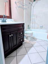 Full bathroom with shower / bath combination with curtain, vanity, toilet, and tile patterned floors